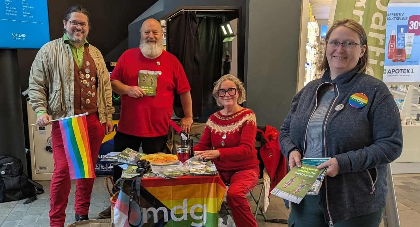 Styret i Sortland MDG smiler mens de deler ut flyers fra stand på sortland storsenter.